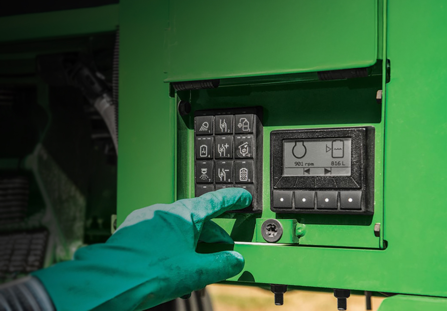 User pushing a button on a CAN busy keypad set in an sprayer panel