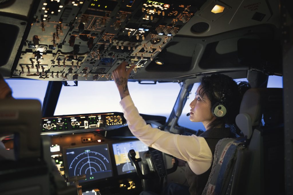 Female pilot turing a rotary switch in a plane cockpit